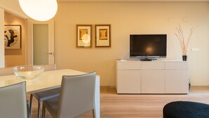 A modern living room with a dining area, a flat-screen TV on a white cabinet, and two framed pictures on the wall. - M Rmara in Javea X bia (Javea)