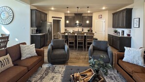 A modern living room with two sofas, a coffee table, and a dining area with chairs.