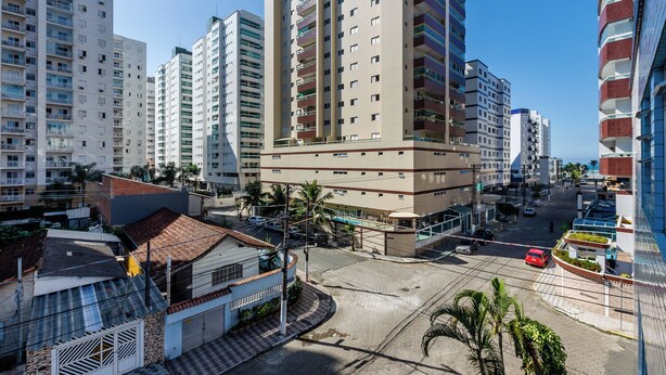 Un edificio de gran altura con varios pisos, un patio central y una calle frente a él.