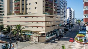 Un hotel de varios pisos con balcones, piscina y estacionamiento.