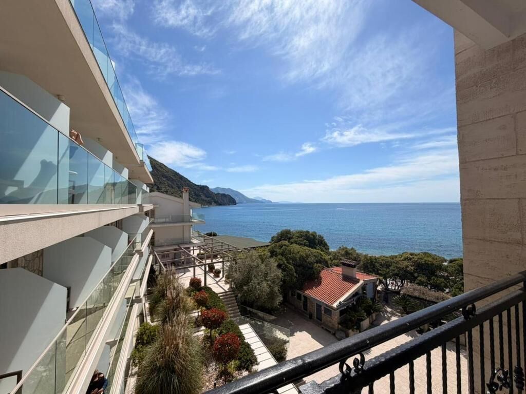 Un balcon avec vue sur la mer et un paysage montagneux.