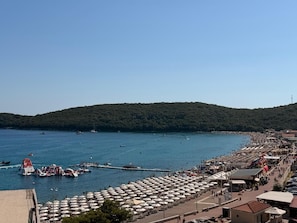 A coastal area with a beach, boats, and umbrellas. - Beachfront Hotel Palma Jaz (Prijevor)