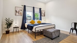 A bedroom with a bed, a nightstand, a potted plant, and a chair. - Skyline Retreat 3br-3ba w Stunning Views Near DT (San Antonio)