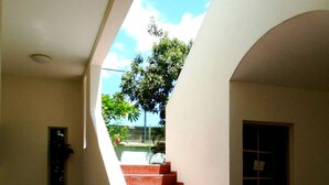 Una escalera que lleva a un espacio al aire libre con vista a árboles y un cielo despejado.