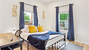 A bedroom with a bed, a desk, and a window with curtains. - 3br-2ba Cityscape Haven With Panoramic Tower View (San Antonio)