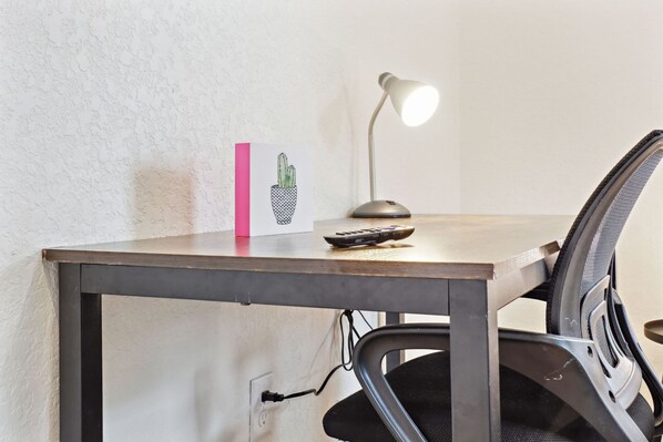 A desk with a lamp, a cactus card, and a calculator. - 3br-2ba Cityscape Haven With Panoramic Tower View (San Antonio)