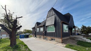 A residential house with a dark exterior, large windows, and a sloped roof. - Welcome to the Raven Rose - A Chic, Newly Renovated 2BD/1BA Home (Logan)