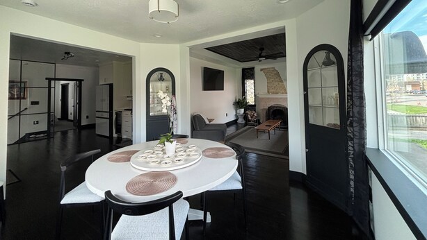 A modern dining area with a round table, chairs, and a vase of flowers. - Welcome to the Raven Rose - A Chic, Newly Renovated 2BD/1BA Home (Logan)