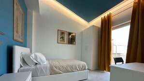 Ein modernes Schlafzimmer mit Bett, Kleiderschrank und Schreibtisch.