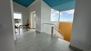 Ein geräumiges Zimmer mit hoher Decke, einer Treppe und Blick zum Himmel.