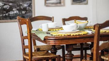 Una mesa con sillas, un cuenco y tazas.