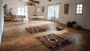A spacious room with a tiled floor, a large window, and a ceiling with exposed beams. - Domaine Castelnaut gîte et château (Laroque-de-Fa)