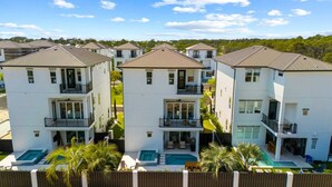 A modern apartment complex with multiple two-story buildings, balconies, and a swimming pool.