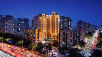 A multi-story hotel with a prominent vertical design, surrounded by other buildings and busy streets.