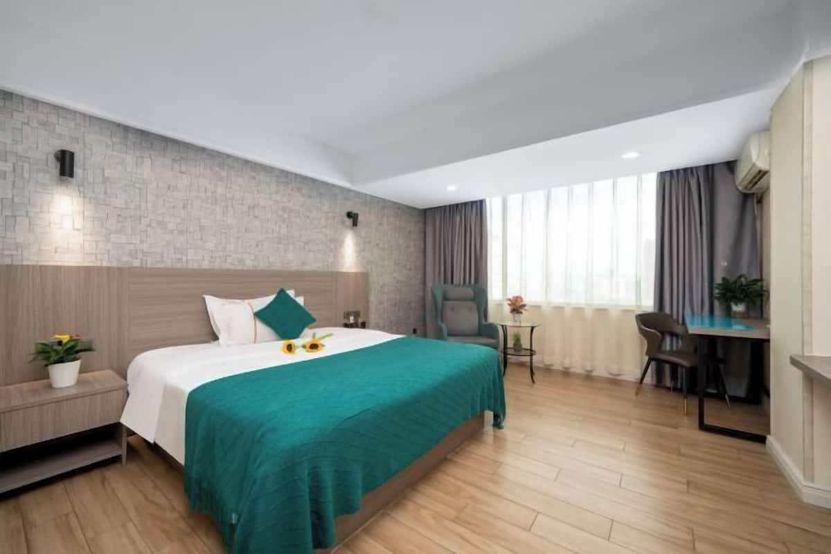 Una habitación de hotel moderna con una cama grande, un escritorio y una silla.