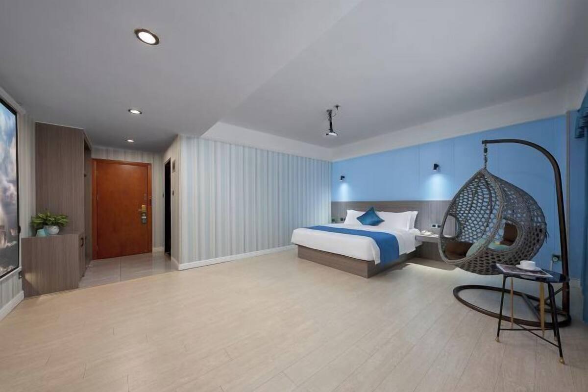 Un dormitorio moderno con cama, sillón colgante y mesita de noche.