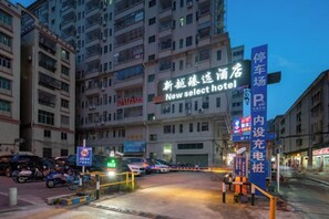 A hotel entrance with a sign for 'New Select Hotel' and a parking sign. - Xinyue Business Hotel (Dongguan)