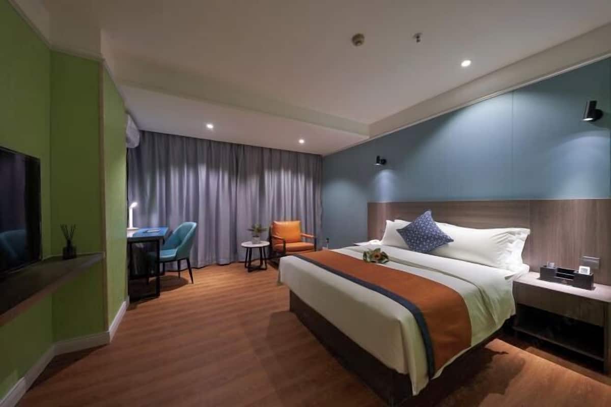 Una habitación de hotel con una cama grande, un escritorio y una silla.