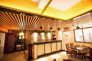 A modern interior with a reception desk, seating area, and a view through a window. - Xinyue Business Hotel (Dongguan)