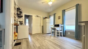 A kitchen with a white refrigerator, microwave, and sink, a dining area with a table and chairs, and a ceiling fan. - 2-bedroom apartment in fabulous Somerville with AC, WiFi and off street parking (Somerville)
