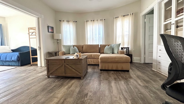 A living room with a sectional sofa, a coffee table, a TV, and a wardrobe. - 2-bedroom apartment in fabulous Somerville with AC, WiFi and off street parking (Somerville)