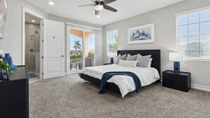 A bedroom with a bed, a nightstand, a ceiling fan, a door leading to a balcony, and a window with blinds. - 148 Mediterranean Way (Indian Harbour Beach)
