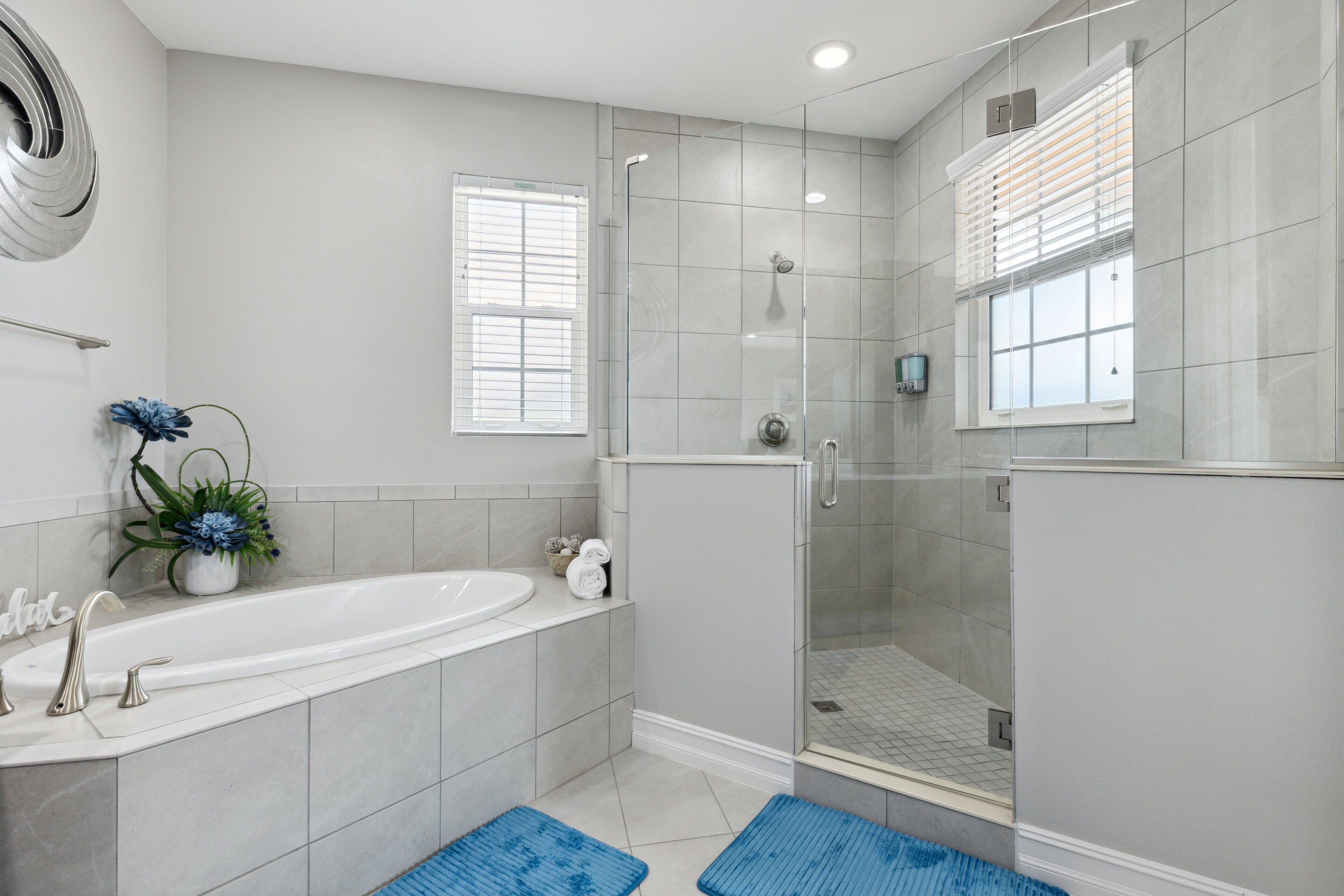 A modern bathroom with a bathtub, shower, and glass-enclosed shower area.