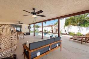 A covered outdoor area with a pool, seating, and a ceiling fan. - 311 Jack Dr (Cocoa Beach)