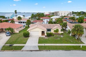 A residential neighborhood with single-family homes, a clear view of the ocean, and a well-maintained lawn.