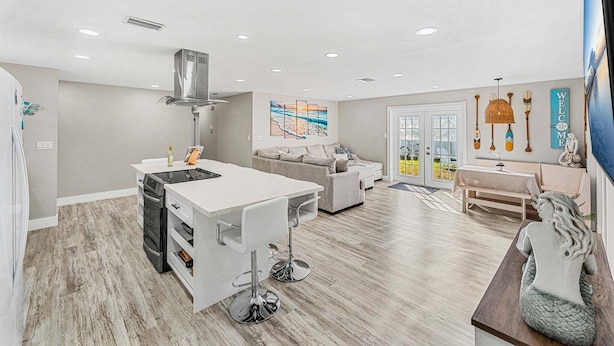 A spacious living area with a kitchen, a dining table, and a sofa. - 332 Formosa Drive (Cocoa Beach)