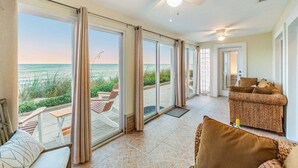 A spacious room with a large sliding glass door leading to a balcony with a view of the ocean. - 3435 S Highway A1A (Melbourne Beach)
