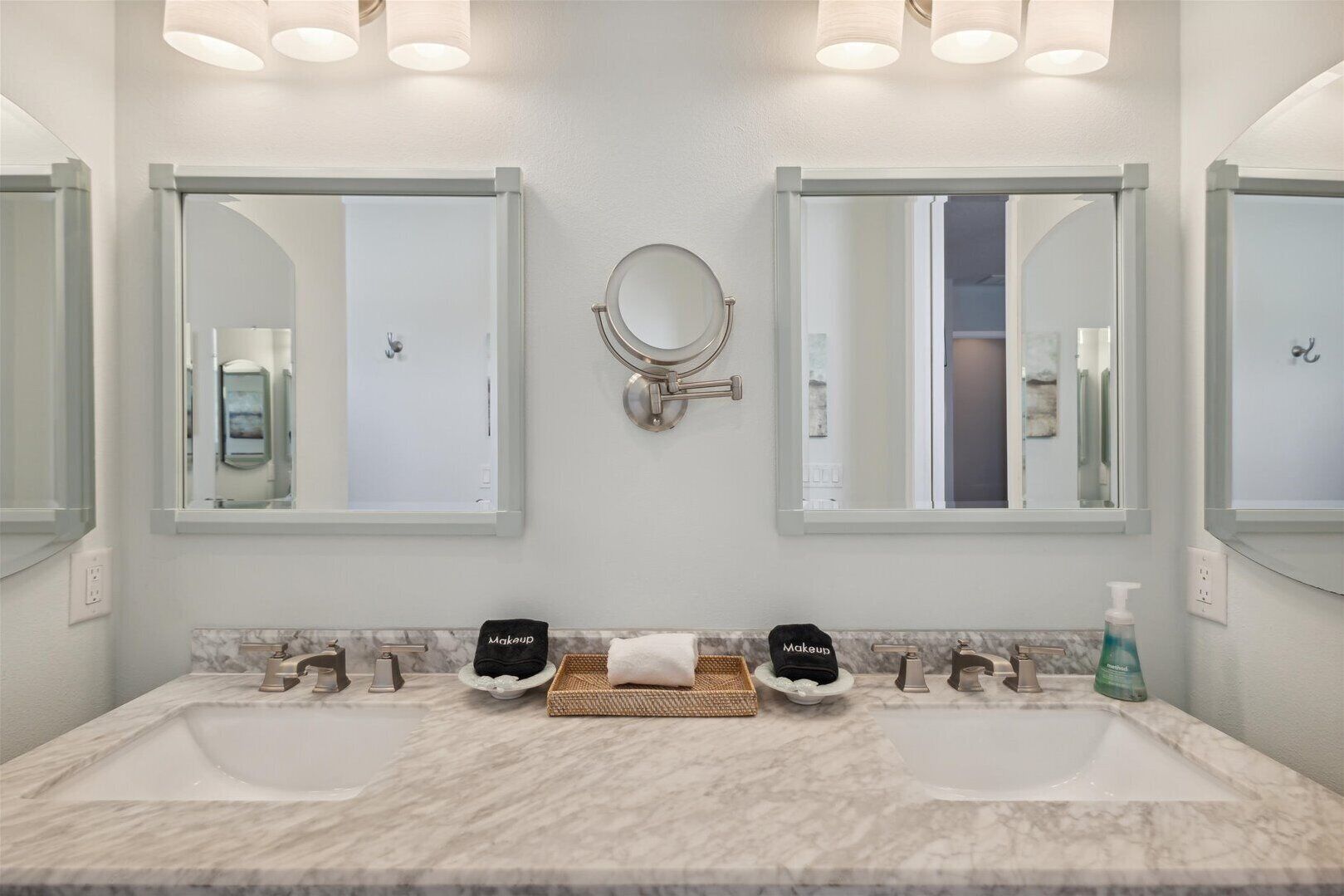 A bathroom with two sinks, a large mirror, and a towel rack.
