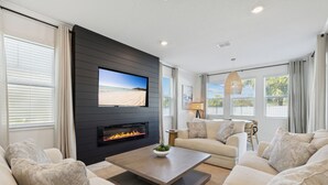 Una sala de estar moderna con chimenea, televisor de pantalla plana y un espacio de estar cómodo.