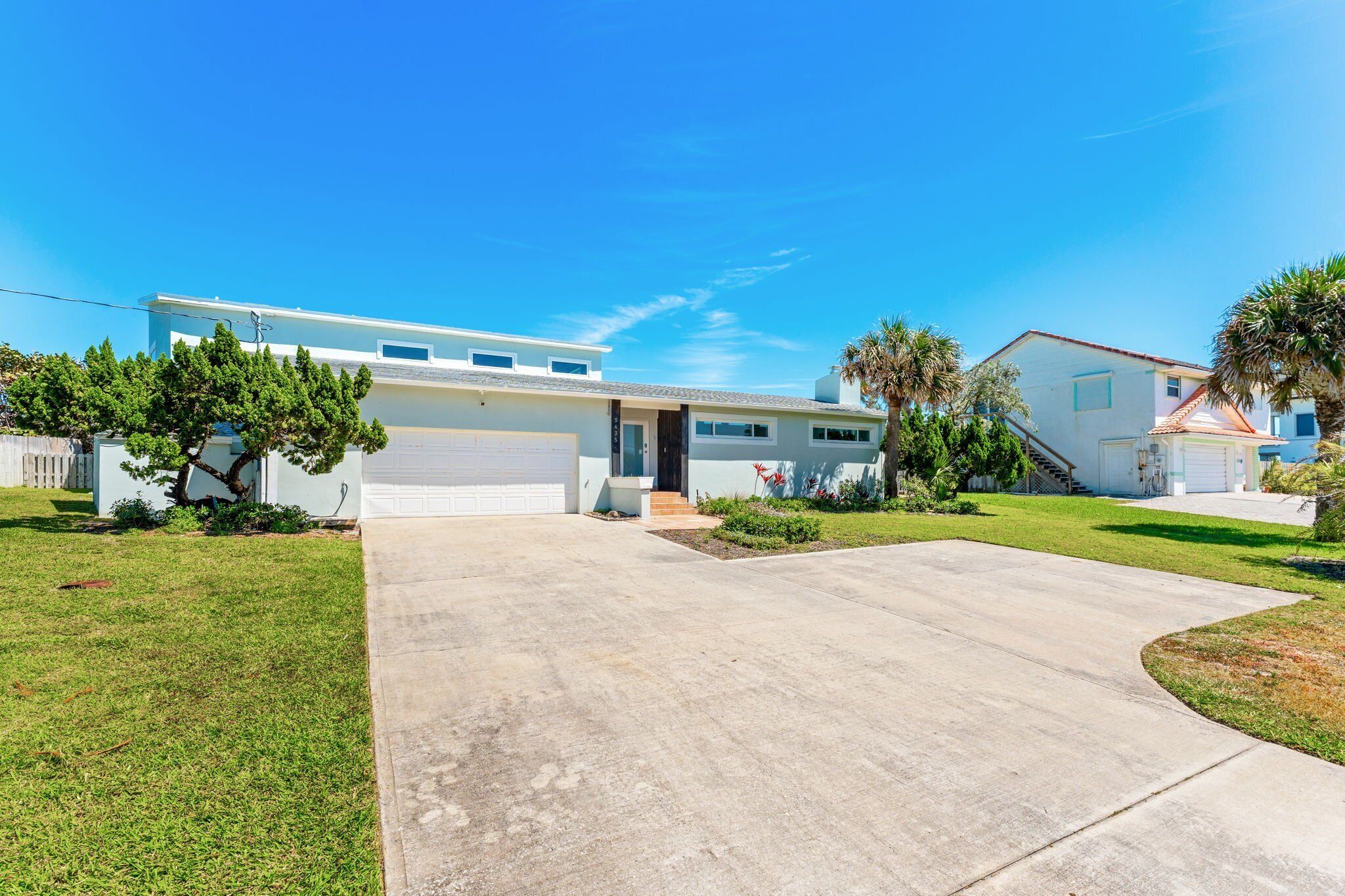 A modern two-story house with a garage, a driveway, and well-maintained lawn.