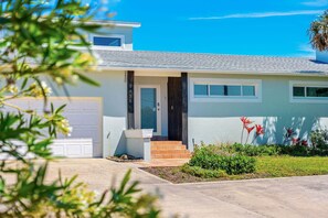 A modern two-story house with a garage, a front door, and a small front porch. - 5435 Highway A1A (Melbourne Beach)