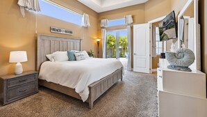 Ein Schlafzimmer mit Bett, Nachttisch, Kommode und einem Schild mit der Aufschrift 'BEACH HOUSE'.