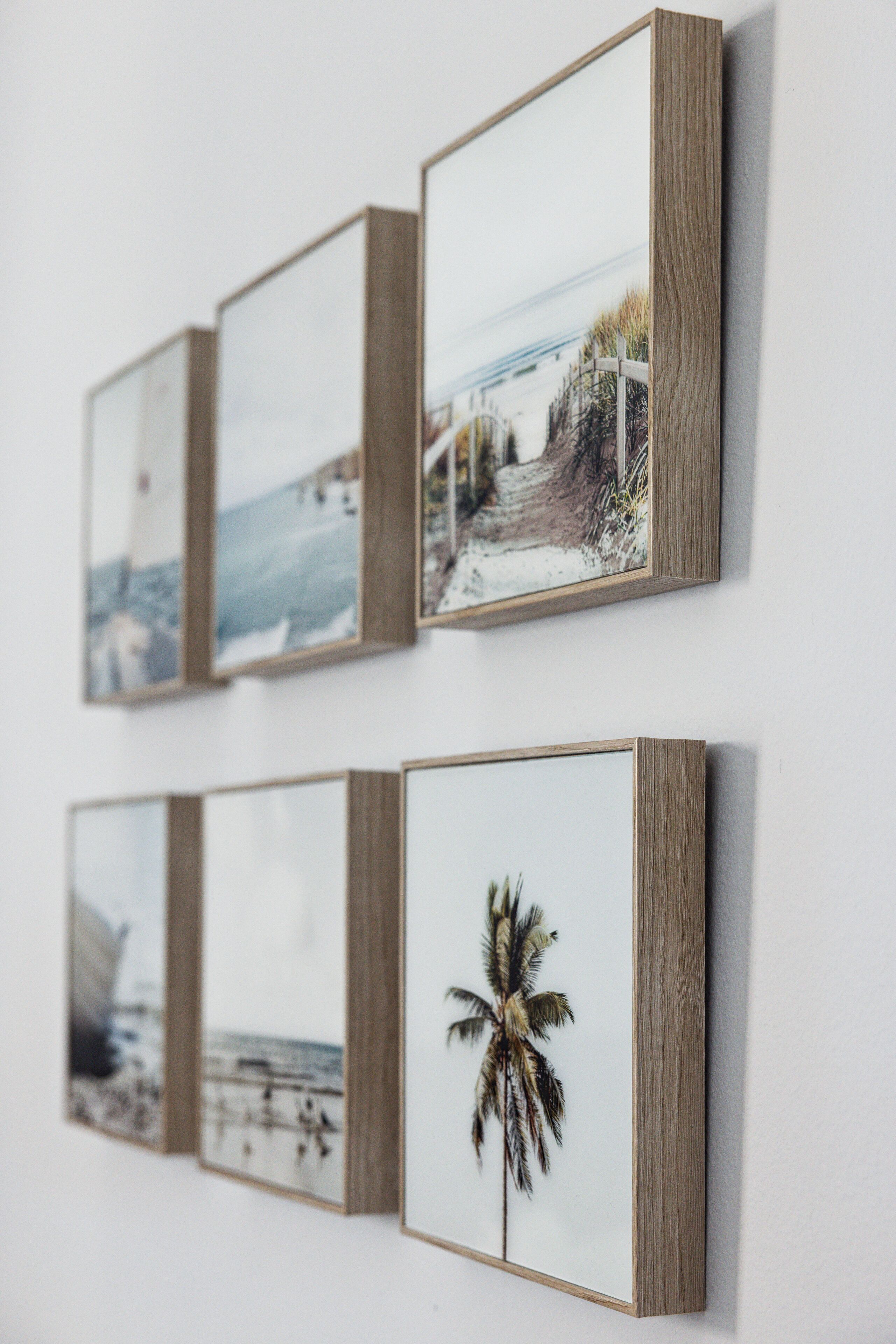 A wall with four framed pictures.
