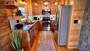 Une cuisine moderne avec des meubles en bois, des appareils électroménagers en acier inoxydable et un îlot central.