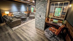 Un salon moderne avec des canapés en cuir, une table basse en bois et un mur décoratif en pierre.