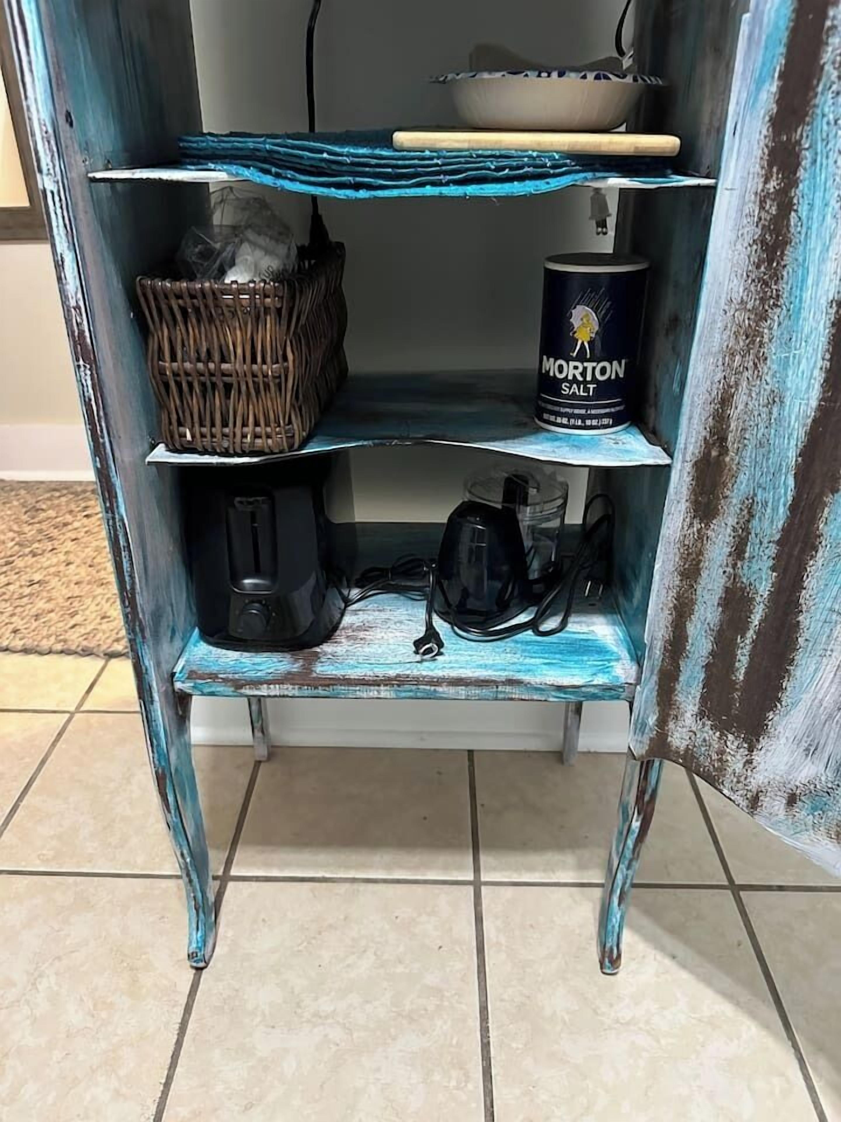 A shelf with a basket, a container of Morton salt, and a black bag.