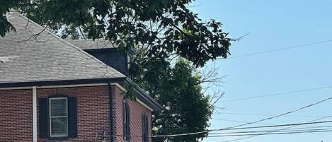 A brick building with a storefront labeled "ANTIQUES" and two American flags.
