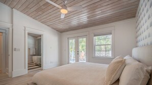 A bedroom with a large bed, wooden ceiling, and a view of the outdoors through a door. - NEW LISTING!!! QUIT 'N TIME - 5BD, LRG PRIV POOL & PATIO, WLK TO SEASIDE & BEACH (Santa Rosa Beach)