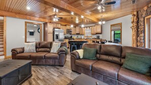 A spacious living area with leather sofas, a coffee table, and a fireplace.