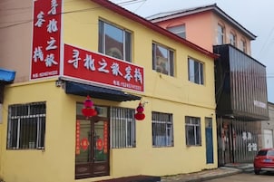 A two-story building with a yellow facade, a red awning, and a signboard with Chinese characters.
