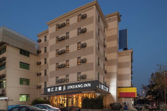 A multi-story hotel with a prominent signage for Ji JINJANG INN.