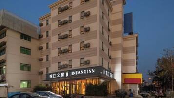 A multi-story hotel with a prominent signage for Ji JINJANG INN.