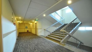 A spacious interior with a carpeted hallway leading to a staircase with a glass railing. - Jinjiang Inn (LinyiWanxianghui Railway Station Hotel) (Linyi)