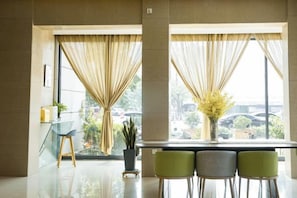 A modern interior with a glass table, two chairs, and a vase with yellow flowers. - Jinjiang Inn (LinyiWanxianghui Railway Station Hotel) (Linyi)