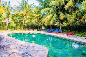 A swimming pool with clear water, surrounded by palm trees and lounge chairs. - Jumbo Art Sign Villa (Diani Beach)