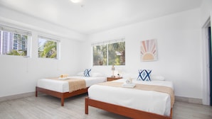 A hotel room with two beds, white walls, and large windows with views of palm trees. - Boutique Apartments SoBe (Miami Beach)